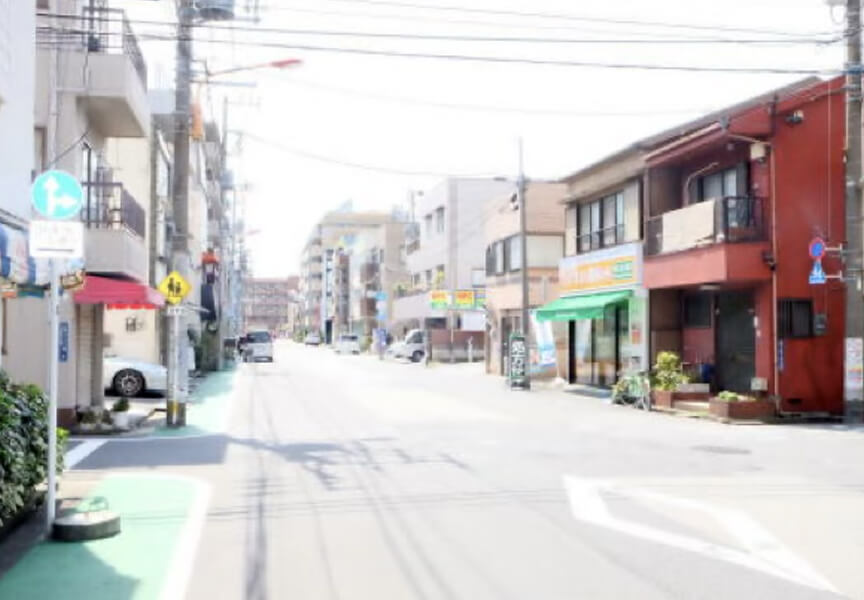 交差点を左に曲がった写真。右手側にひまり薬局菊川店が、その奥の左側に当院の看板が見えます。